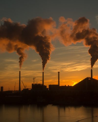 low-angle-shot-factory-with-smoke-steam-coming-out-chimneys-captured-sunset-1